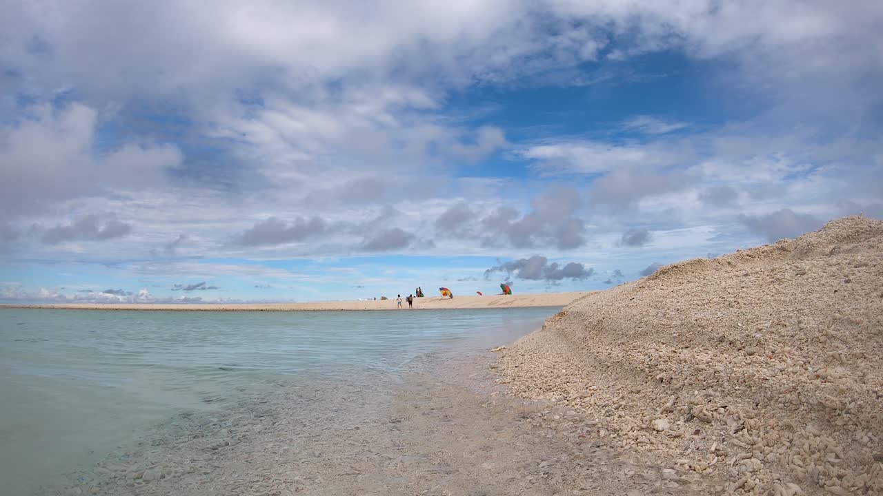 cerca de las olas lavando suavemente contra una playa de arena con gente en el fondo caminando en la isla filipina 4k