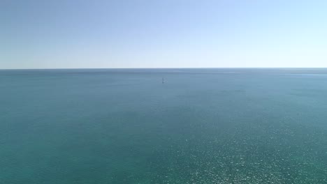nothing but the clear blue ocean and a sail boat