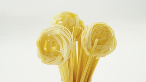 Spaghetti-arranged-in-flower-shaped-on-white-background-in-glass-jar