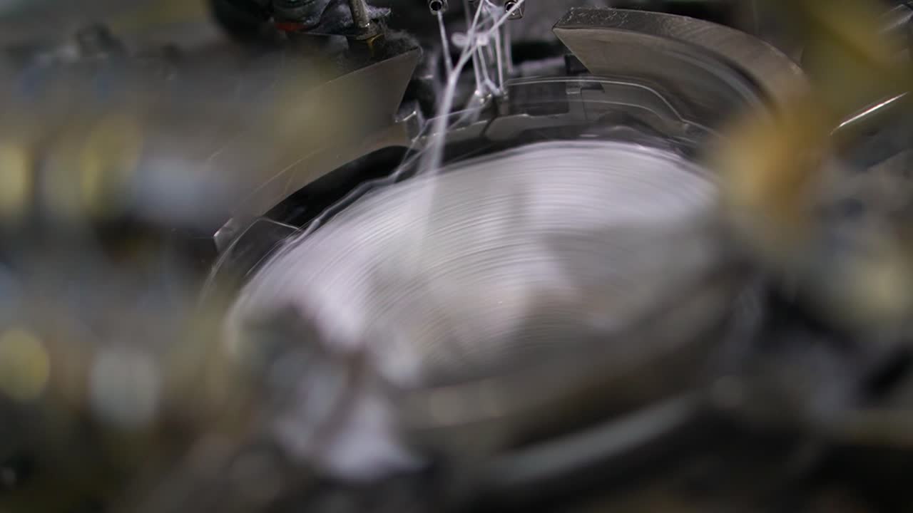 partes cercanas de la máquina con hilos, el proceso de producción en una fábrica de prendas de vestir, proceso automatizado, fabricación de calcetines