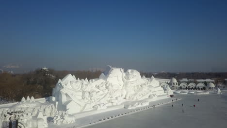 los visitantes del festival de hielo de harbin se reúnen en un estanque congelado, esculturas de nieve