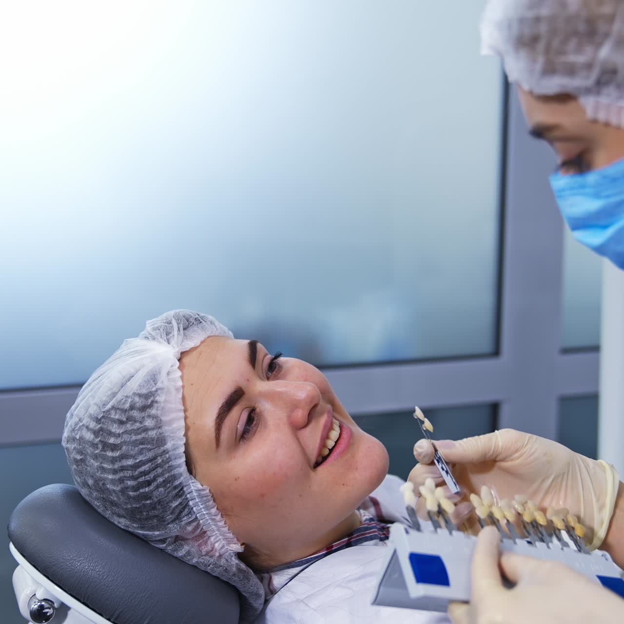 Dentistry student trying to find the sample of tooth color according to the patient's teeth. Two students at practical lessons
