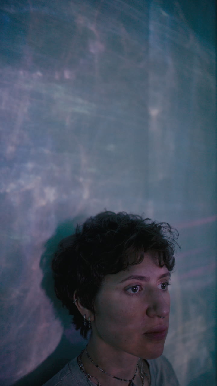 Dreamy Woman Leaning against Wall with Soft Light Projection