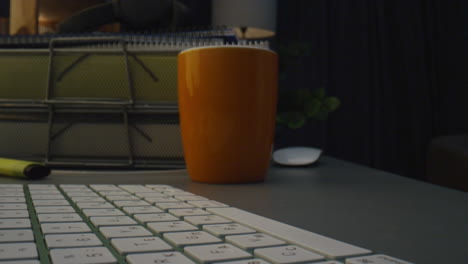 Guy-hands-texting-keyboard-buttons-dark-interior.-Man-fingers-working-computer