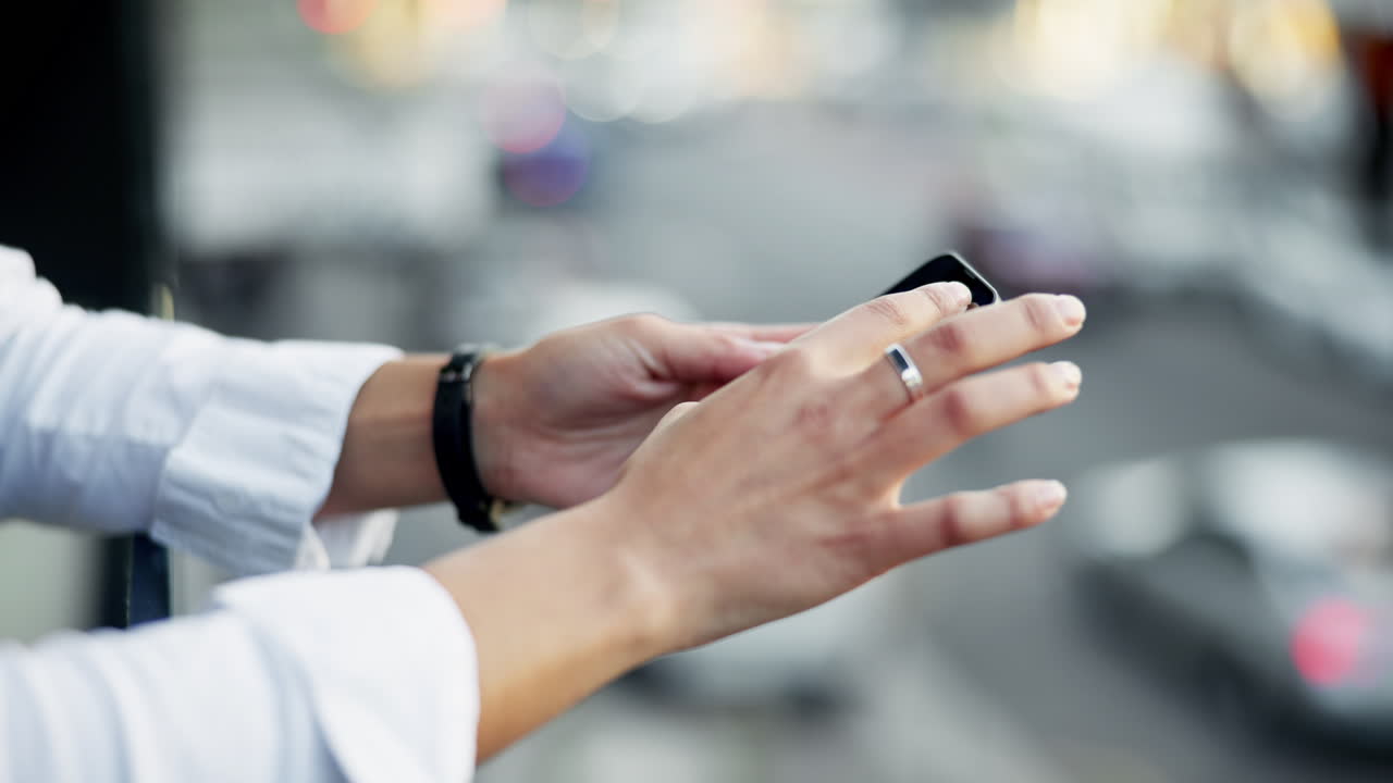 Hands using mobile phone in city