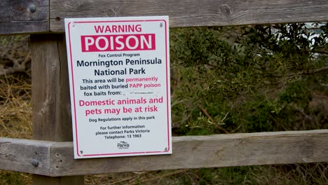 Warning sign alerts visitors to poison bait danger for pets on national park walking track