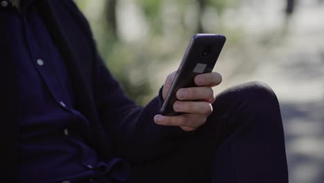 Cropped-shot-of-young-man-using-smartphone-outdoor