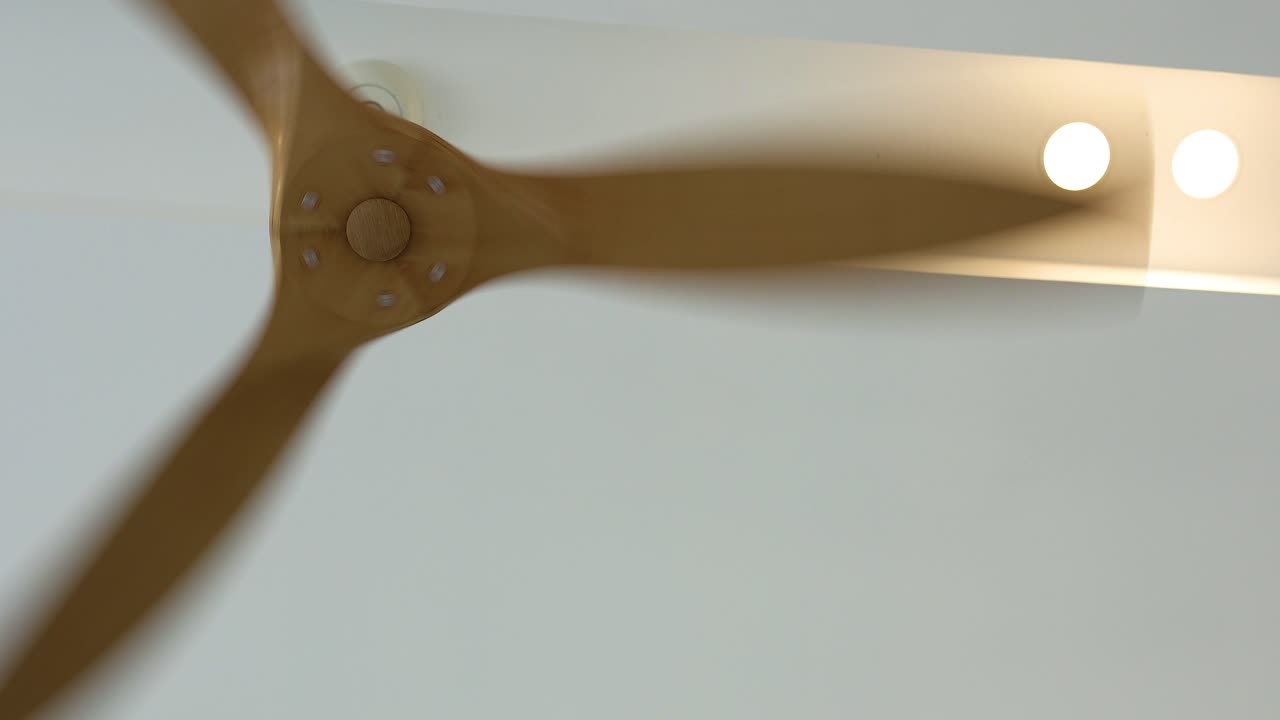 천장 팬이 밝은 배경에 대해 회전합니다.