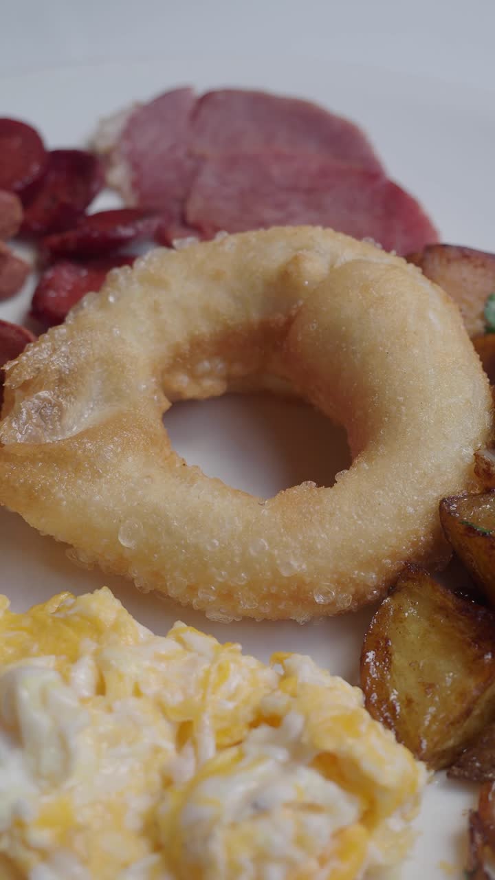 Delicioso plato de desayuno con huevos, patatas, jamón y salchicha