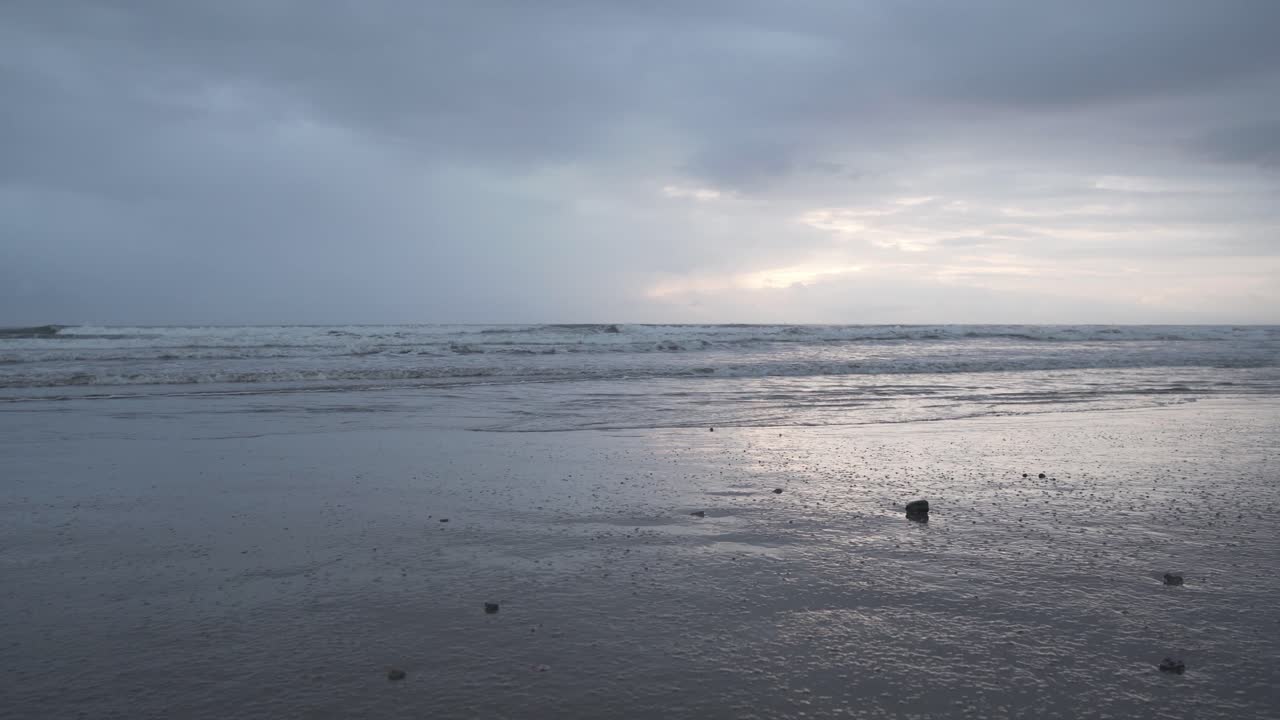 에콰도르 올론의 흐린 구름과 함께 모래사장에 튀는 파도 - 지상 수준, 정적 샷