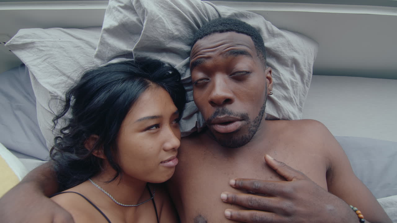 Top View of Young Couple Embracing and Speaking in Bed