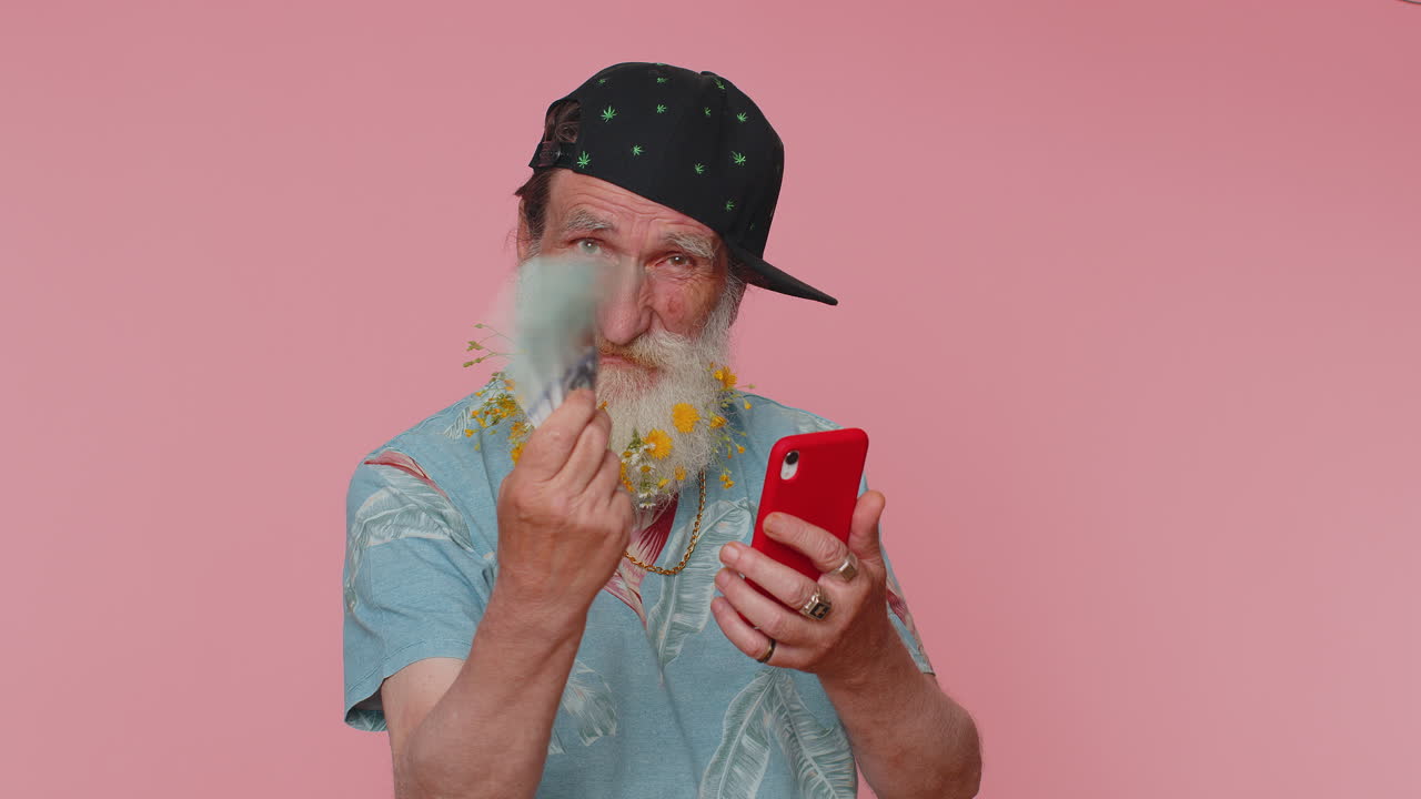 пожилой человек использует смартфон радуется победе, получает деньги доллар наличные банкноты, успех лотерея удача