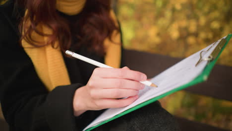 close up of artist sketching thoughtfully on canvas with blurred autumn leaves in background, focus on artistic expression, pencil strokes, and deep concentration in serene outdoor setting