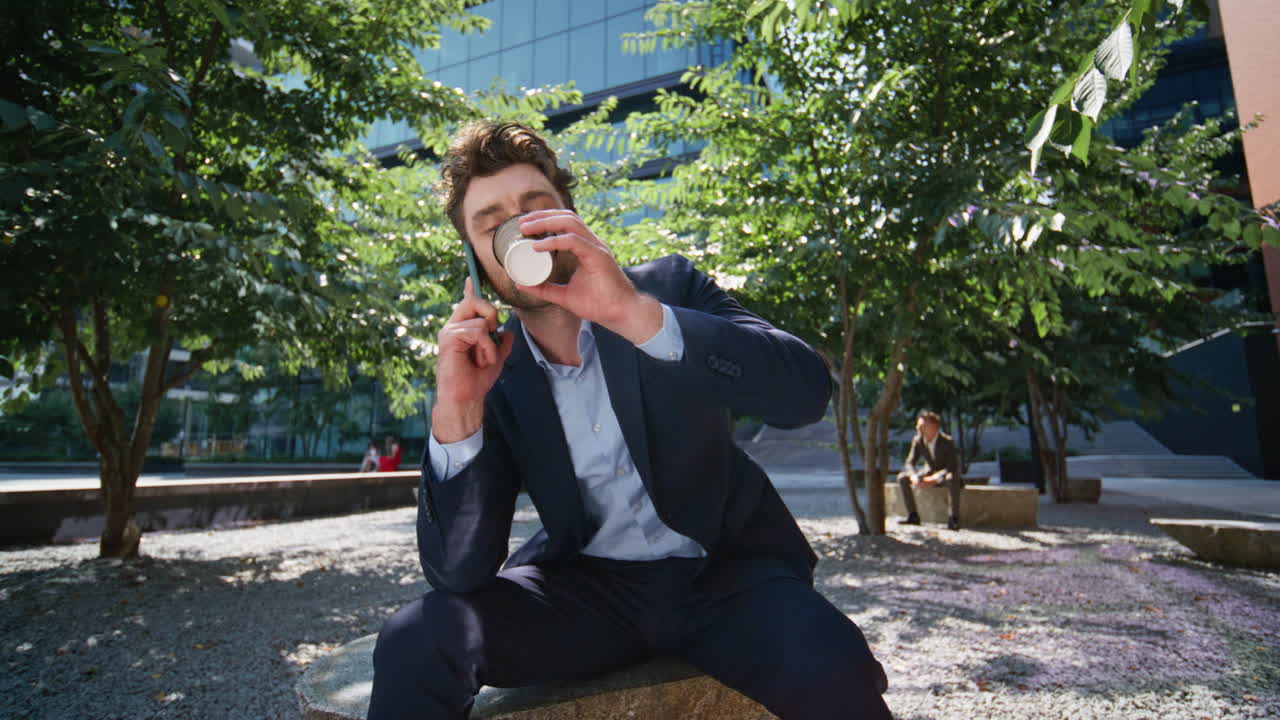 도시 공원에서 커피를 마시는 쾌활한 남자. 웃는 사업가 이야기