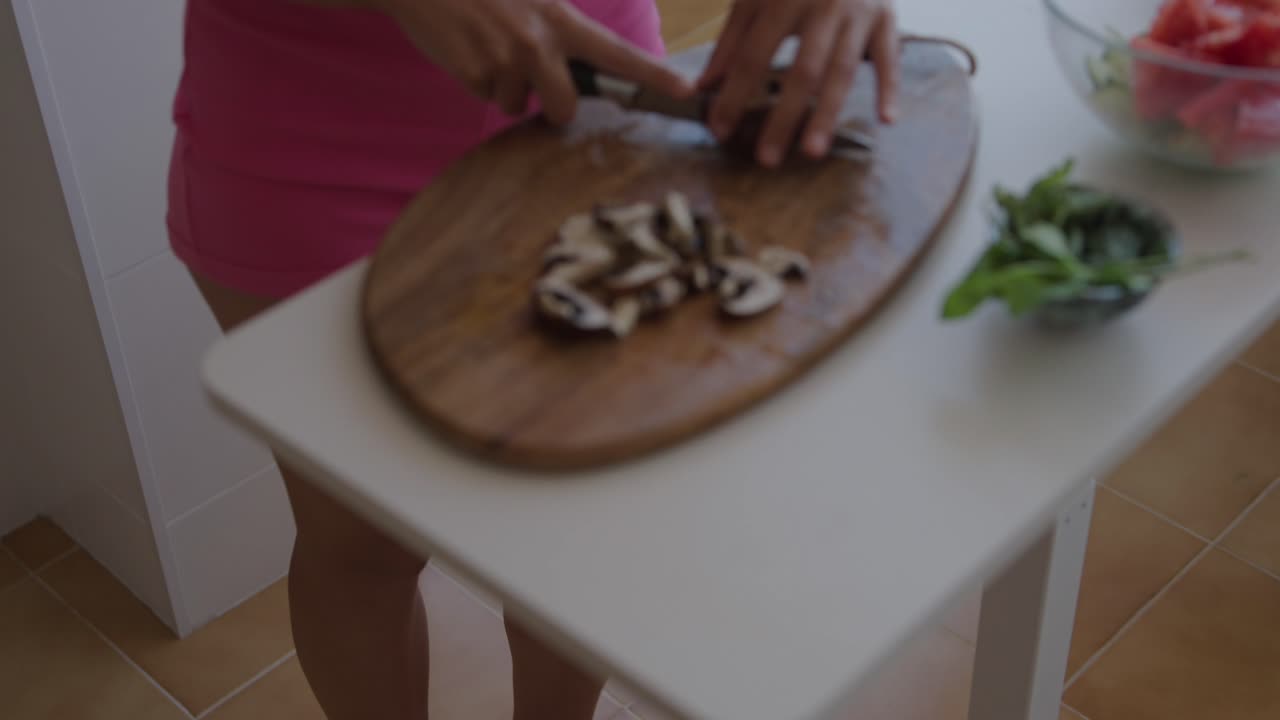 Woman preparing salad with mushrooms