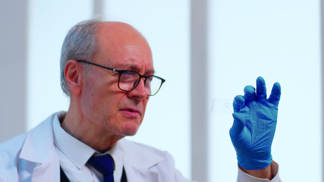 Old scientist man analysing virus sample in modern laboratory