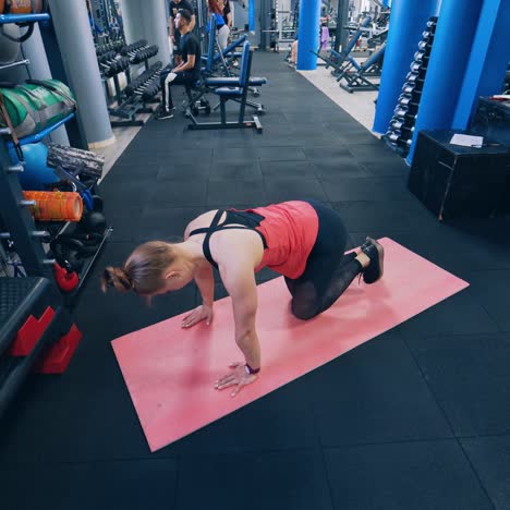 top view of a woman training on a mat. view from above on a girl in sportswear doing workout in the fitness centre. sports and fitness training. healthy lifestyle.