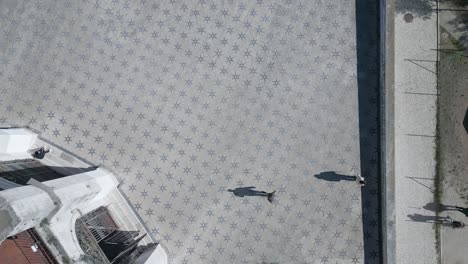 aerial vertical view of a historic residential district in lisbon, portugal, with people walking and casting beautiful shadows