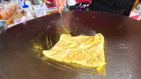 vendor prepares pan-fried roti in kanchanaburi