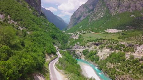 camino sinuoso junto a un río azul en los hermosos valbona kukes de los alpes albaneses, en europa del este