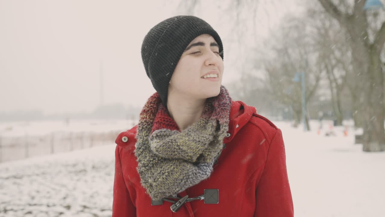 눈이 내리는 동안 걷는 검은 보닛 모자를 쓴 젊은 여성, 겨울