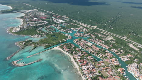 aerial-view-in-dolly-in-of-a-coastal-city,-full-of-vibrant-architecture-and-pristine-beaches-surrounded-by-the-majestic-sea-in-Mexico