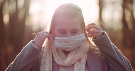 woman putting on protective mask against coronavirus