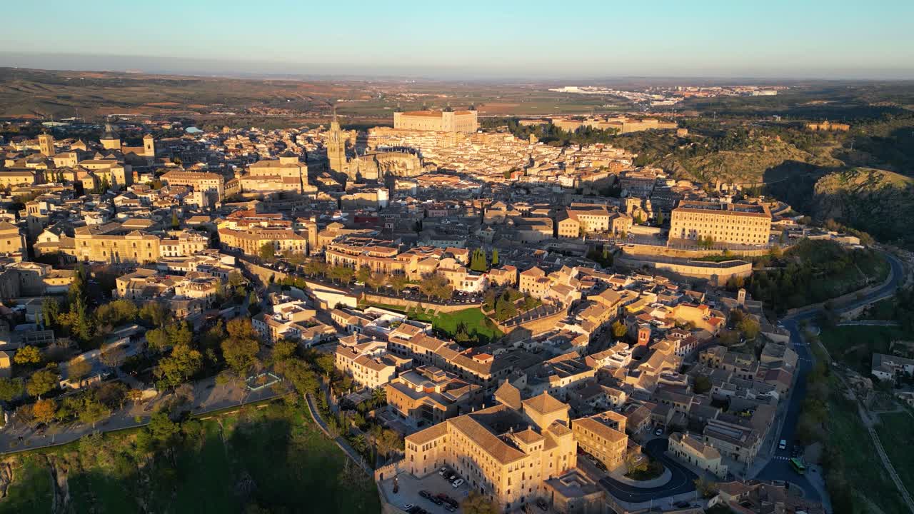 Filming with a drone in the golden hour of the city of Toledo from its south-west area, we see its emblematic buildings and how that golden light is projected on them, the shadows are introduced