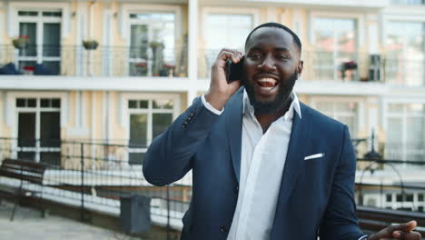 Winner-afro-businessman-celebrating-victory-outside.-African-man-dancing-street