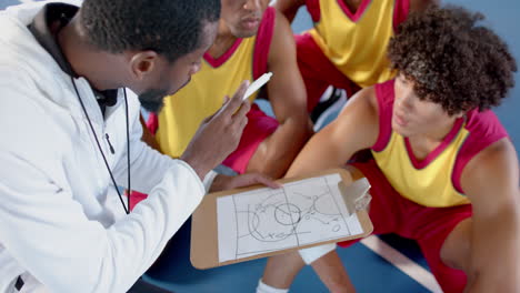 african american coach discussing strategy with young players at a sports facility