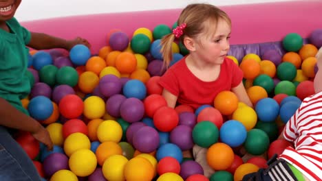 niños felices todos jugando en un pozo de pelota