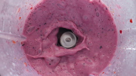 berry milkshake splashing blender in super slow motion close up. tasty smoothie.