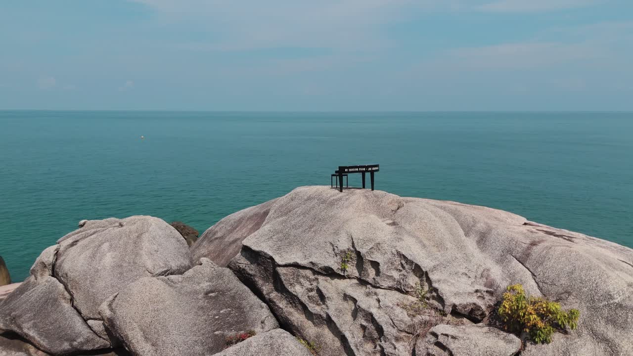 Solitary piano on rocks in Koh Phangan bay, Thailand