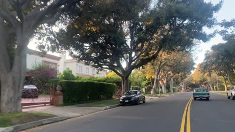 coche clásico conduciendo por una carretera residencial