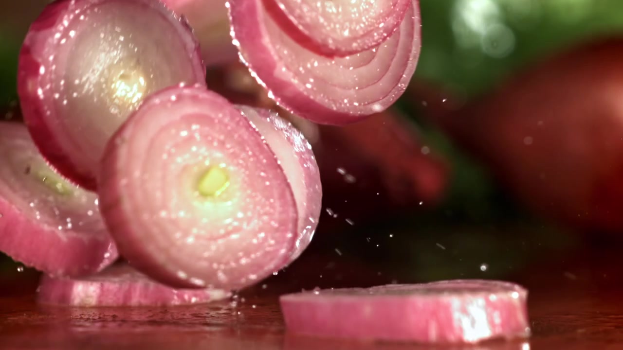 Red Onion Slices Falling and Splashing in Slow Motion