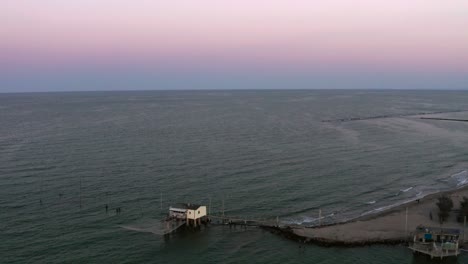 aerial shot of the valleys near ravenna where the river flows into the sea with the typical fishermen's huts at sunset