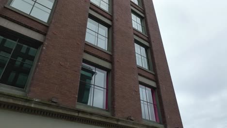 rising aerial view of a brick building with glass windows in downtown seattle