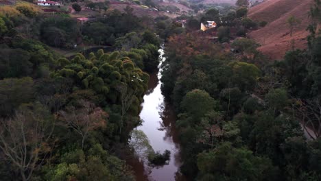 Drone-flying-over-a-narrow-canal-and-a-road-beaside-it