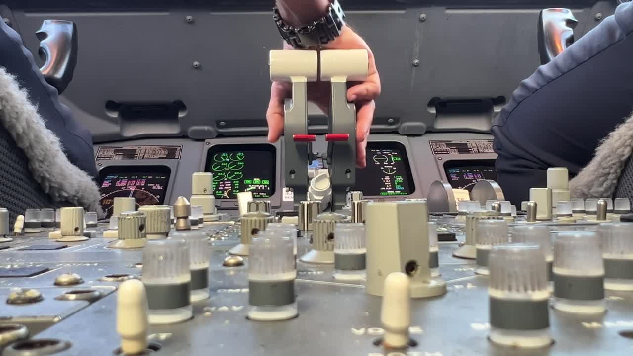 기장이 오른손으로 엔진 가속기를 조종하는 동안 엔진 제어 패널의 제트 조종실 내부의 낮은 각도 뷰