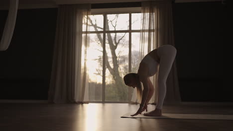 a group of women practice yoga under the strict guidance of an instructor in slow motion and sunlight at sunrise.