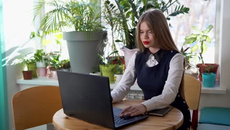 mujer trabajando en una computadora portátil en un café