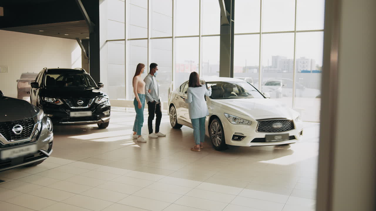 clientes de la sala de exposiciones de automóviles viendo un coche blanco