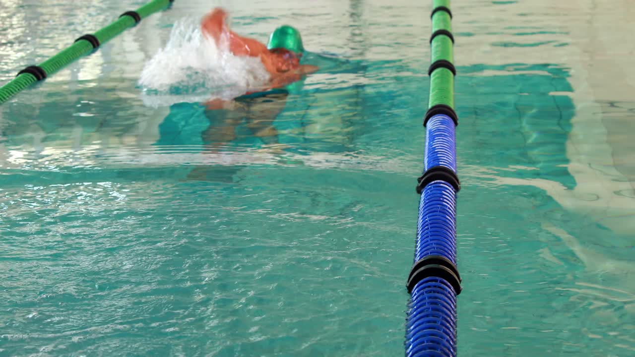 Homem em forma mergulhando na piscina e nadando