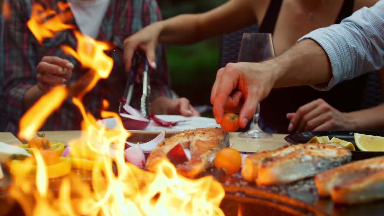 인식할 수 없는 여성이 bbq 음식을 요리하고 있습니다.