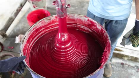 mixing red liquid in a factory