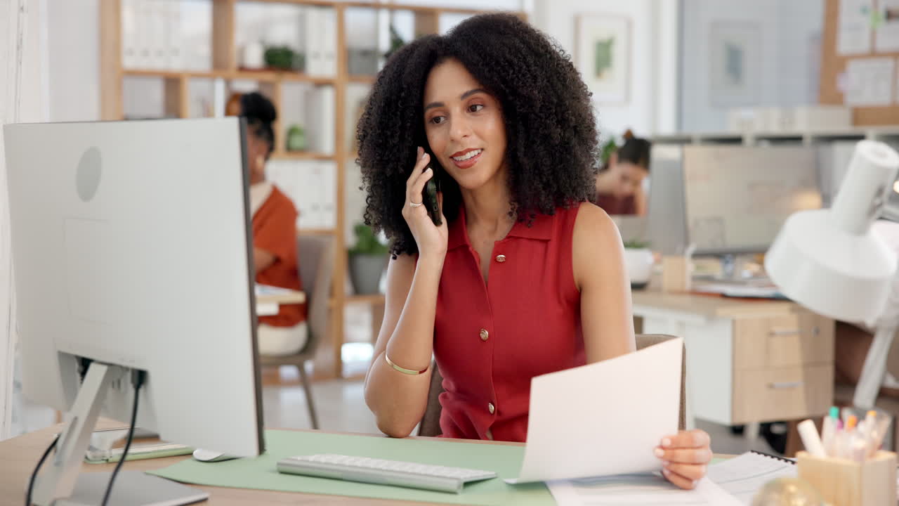 Donna professionista che parla al telefono e rivede documenti in ufficio