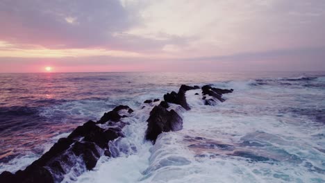 sunrise over the ocean with dramatic waves and rocks