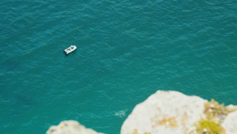 Pequeño-Barco-Pesquero-Con-Océano-Azul-Y-Colina-Montañosa