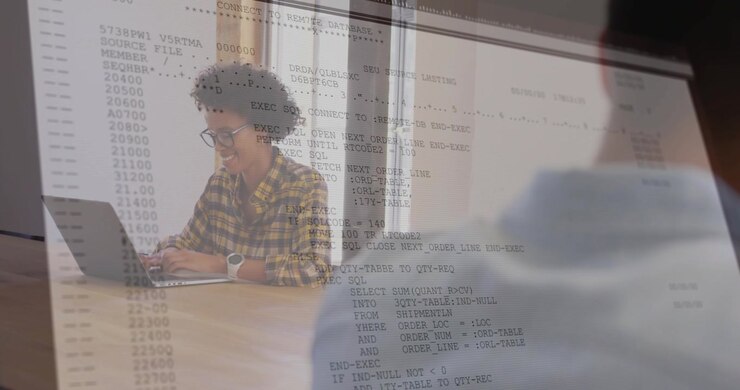 Woman coding on laptop behind shoulder, showing code overlay growing across frame for tech review