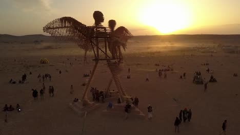 giant wooden angel sculpture at desert festival sunset